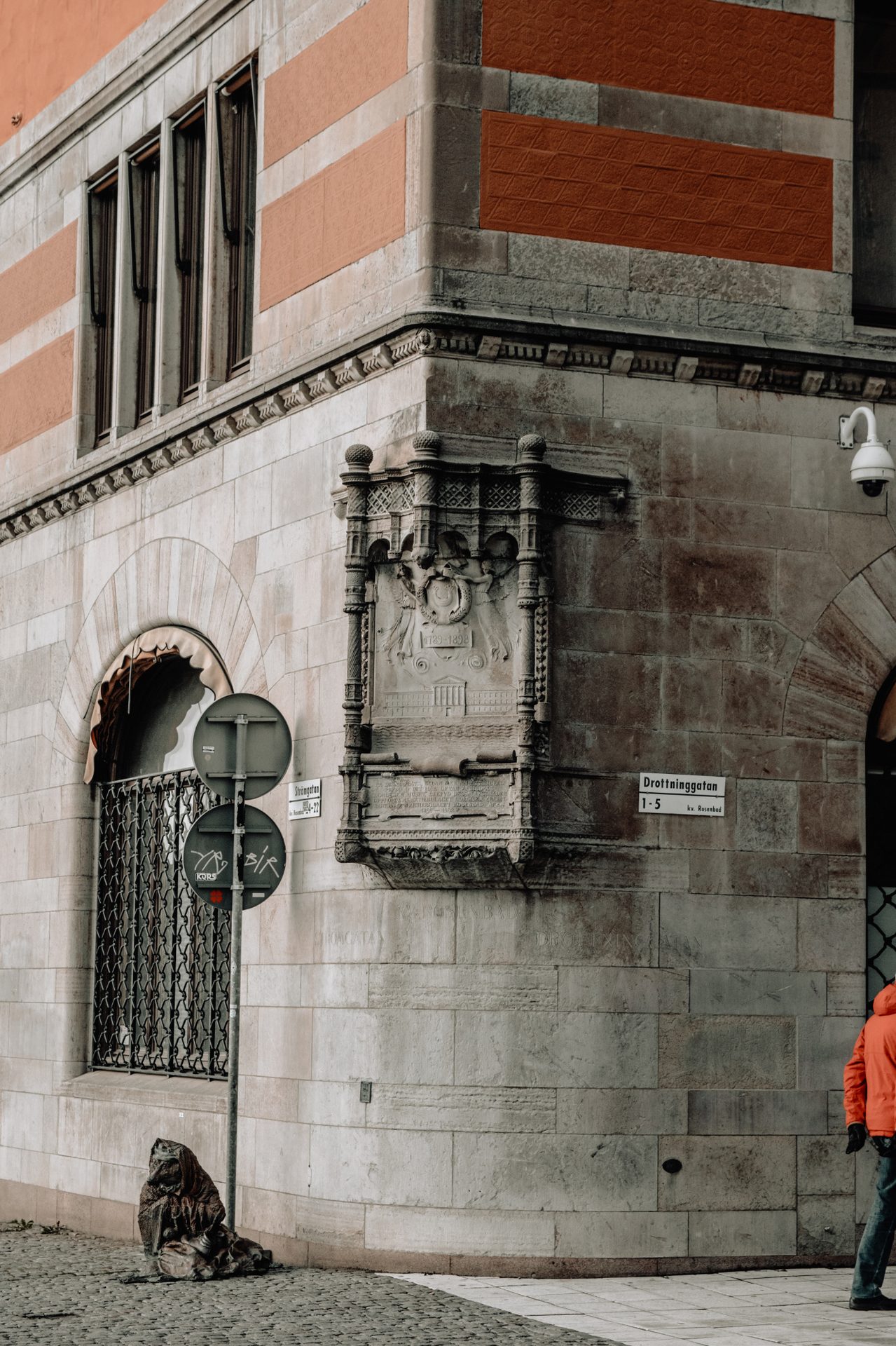Stone doorway and a seated person beside a Stockholm church
