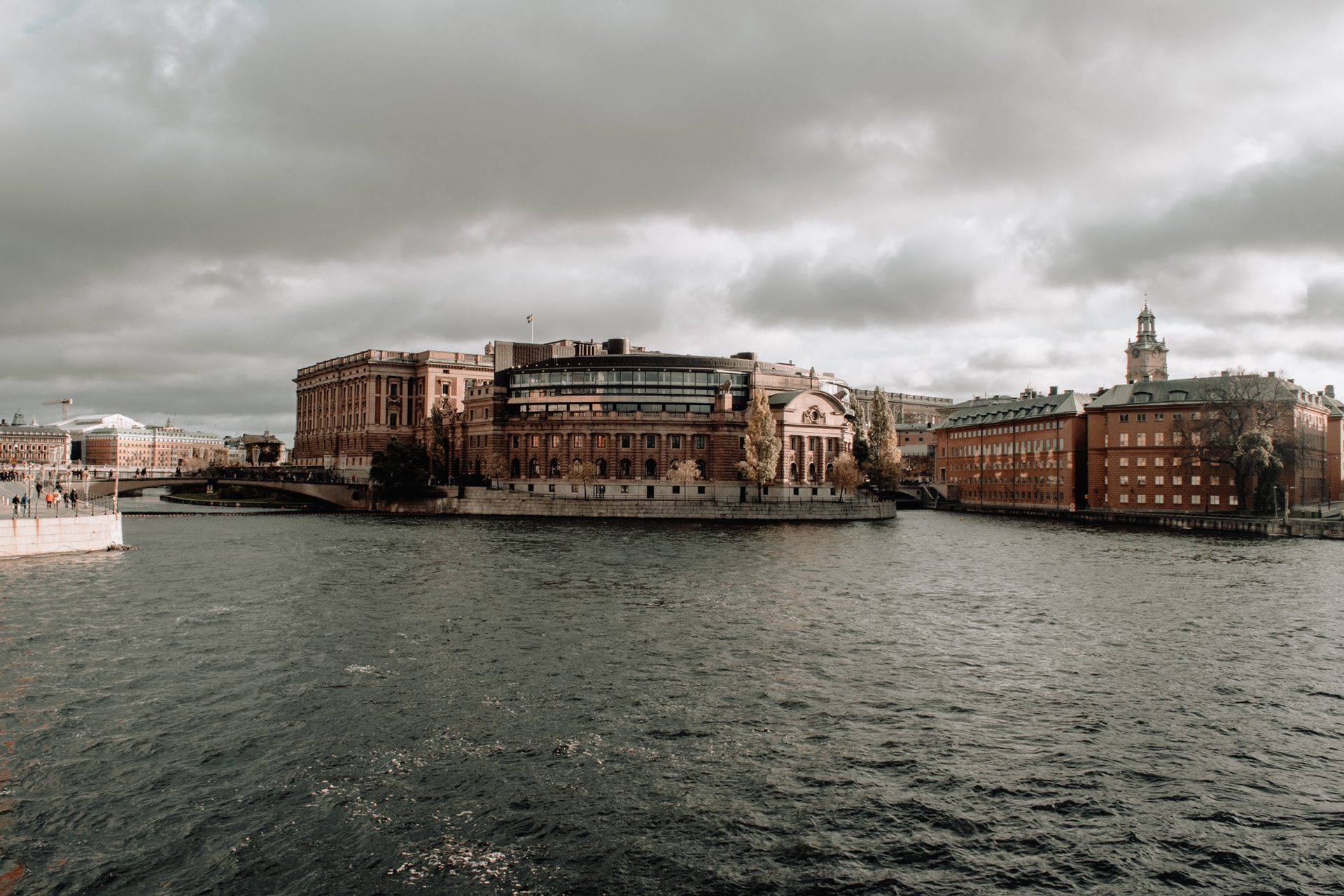 Historic Stockholm waterfront buildings beneath grey clouds